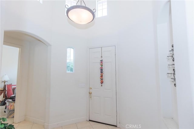 1490 N Dewitt Ave, Clovis, CA 93619 - foyer entrance with light tile patterned floors, a healthy amount of sunlight, a towering ceiling, and arched walkways