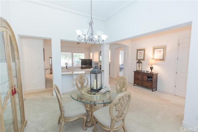1490 N Dewitt Ave, Clovis, CA 93619 - dining area with light colored carpet, arched walkways, baseboards, and a notable chandelier
