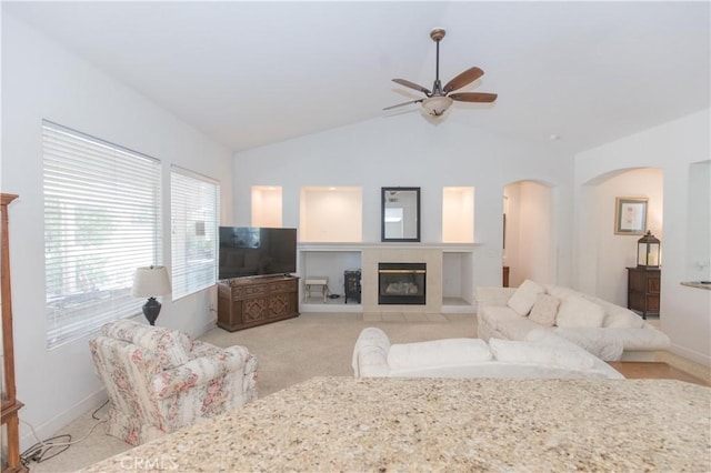 1490 N Dewitt Ave, Clovis, CA 93619 - carpeted living area with a ceiling fan, a tiled fireplace, baseboards, arched walkways, and lofted ceiling