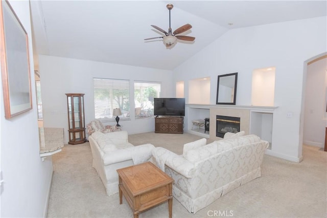 1490 N Dewitt Ave, Clovis, CA 93619 - living room with lofted ceiling, a ceiling fan, a glass covered fireplace, arched walkways, and light carpet