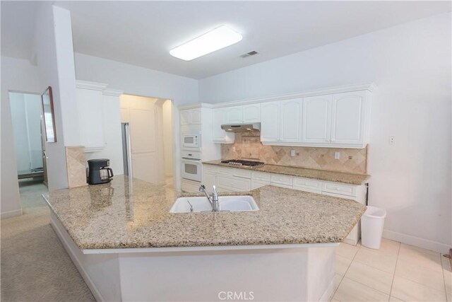 1490 N Dewitt Ave, Clovis, CA 93619 - kitchen with a peninsula, a sink, white cabinets, white appliances, and decorative backsplash
