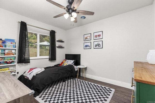 bedroom featuring baseboards, dark wood-style flooring, and a ceiling fan