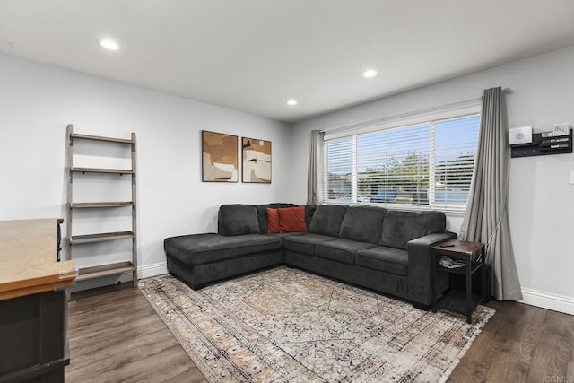 living room featuring dark wood-style flooring, baseboards, and recessed lighting
