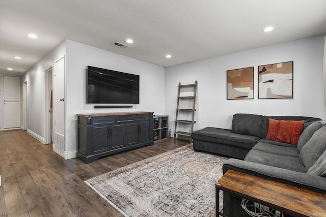 living area featuring baseboards, dark wood-style flooring, visible vents, and recessed lighting
