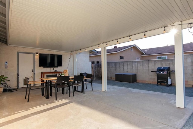 view of patio / terrace featuring a grill, fence, and outdoor dining space