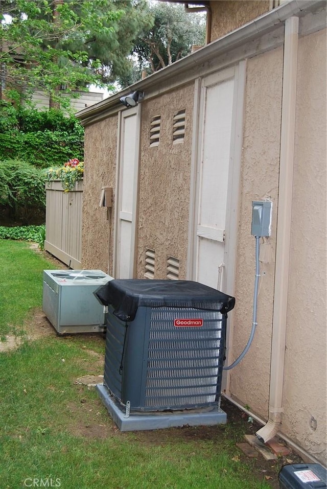 exterior details featuring stucco siding and central AC
