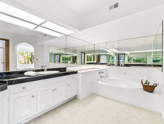 bathroom with vanity, a garden tub, visible vents, and recessed lighting