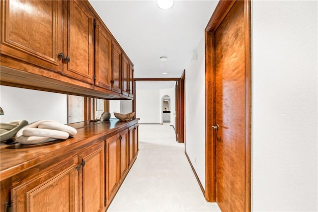hallway with light colored carpet, arched walkways, and recessed lighting