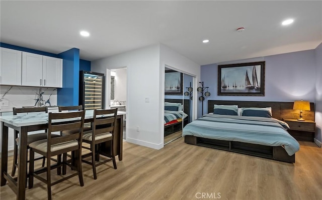 bedroom with recessed lighting, baseboards, light wood-type flooring, and beverage cooler