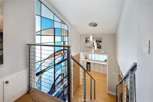 stairs with wood finished floors and baseboards