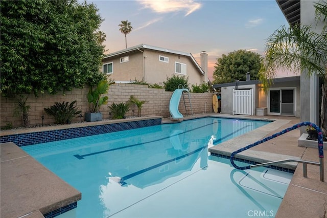 view of pool with fence, a water slide, and a fenced in pool