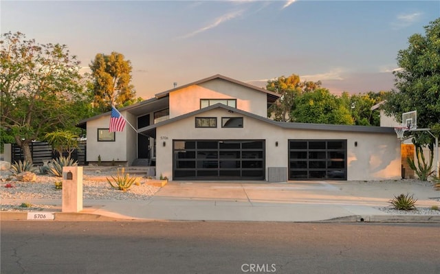 modern home featuring concrete driveway, an attached garage, and stucco siding