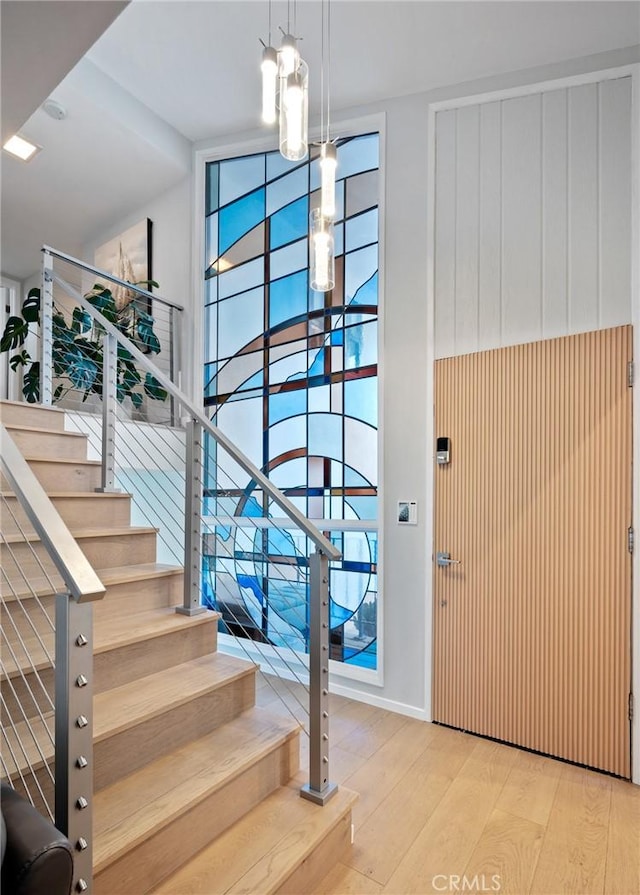 entryway with a wealth of natural light, wood finished floors, and stairs