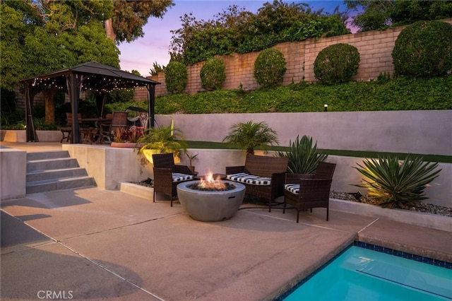 exterior space featuring a fire pit, a gazebo, and a fenced in pool