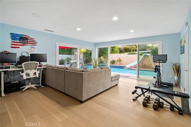 living area featuring recessed lighting, light wood-style floors, and visible vents