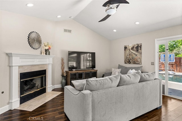living area with a ceiling fan, a fireplace, visible vents, dark wood-style flooring, and lofted ceiling