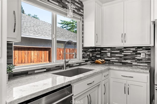 kitchen featuring a sink, white cabinetry, light stone countertops, dishwasher, and tasteful backsplash