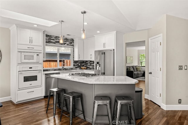 kitchen featuring recessed lighting, a sink, a kitchen breakfast bar, tasteful backsplash, and appliances with stainless steel finishes