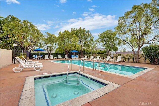 pool featuring a hot tub, fence, and a patio