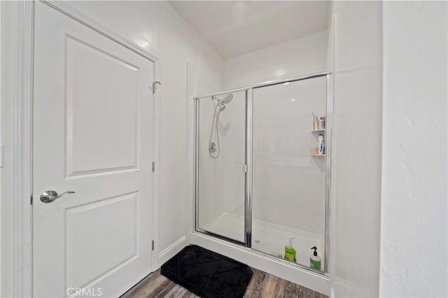 full bathroom with a shower stall and wood finished floors
