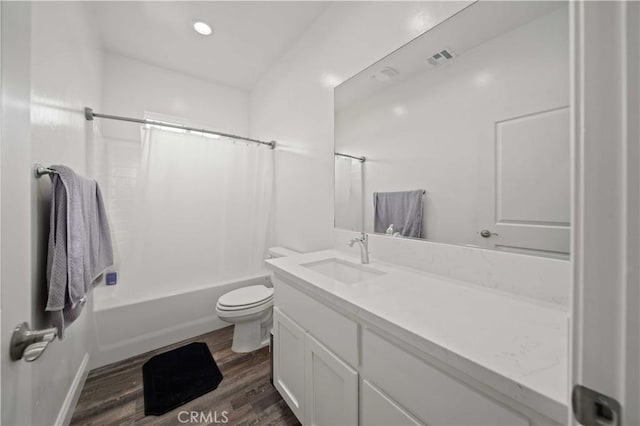 bathroom featuring toilet, wood finished floors, vanity, visible vents, and shower / bathtub combination with curtain