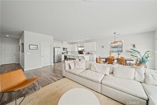 living area featuring recessed lighting, baseboards, and light wood-style floors