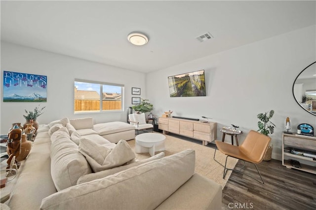 living room featuring visible vents and dark wood-style flooring