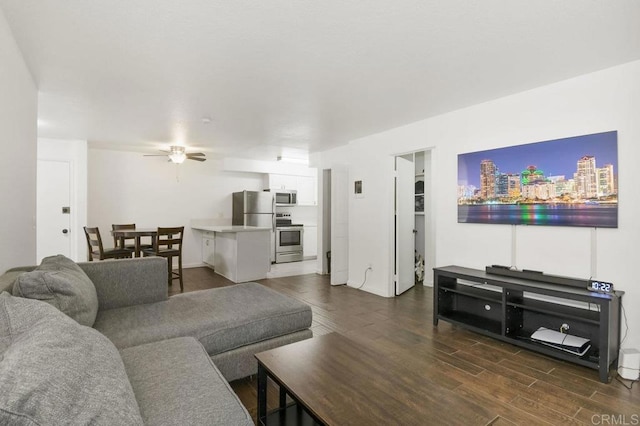 living room featuring a ceiling fan, a view of city, and dark wood-type flooring