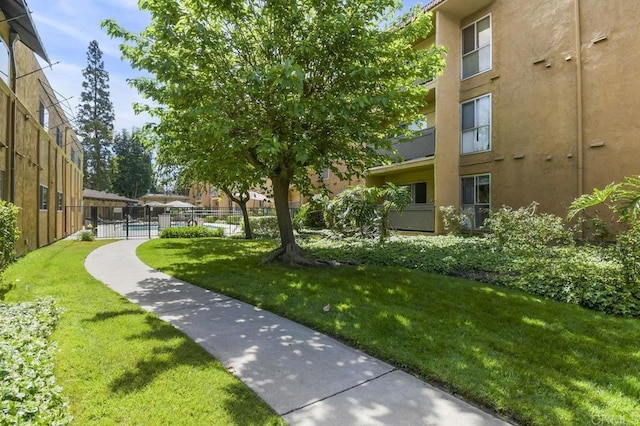 view of community with fence and a lawn