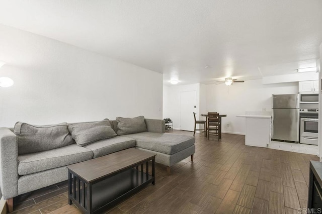 living area featuring ceiling fan and dark wood finished floors