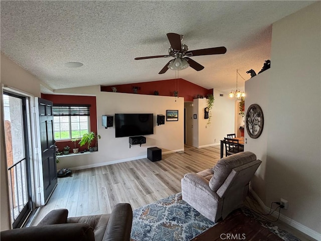 living area featuring wood finished floors, a textured ceiling, vaulted ceiling, a ceiling fan, and baseboards