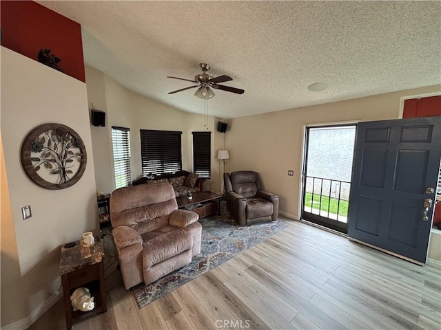 living area with a wealth of natural light, ceiling fan, a textured ceiling, and wood finished floors