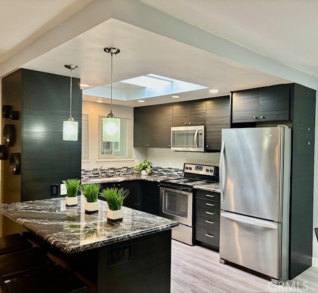 774 Via Los Altos Unit P, Laguna Woods, CA 92637 - kitchen with appliances with stainless steel finishes, light stone countertops, decorative light fixtures, a sink, and light wood finished floors