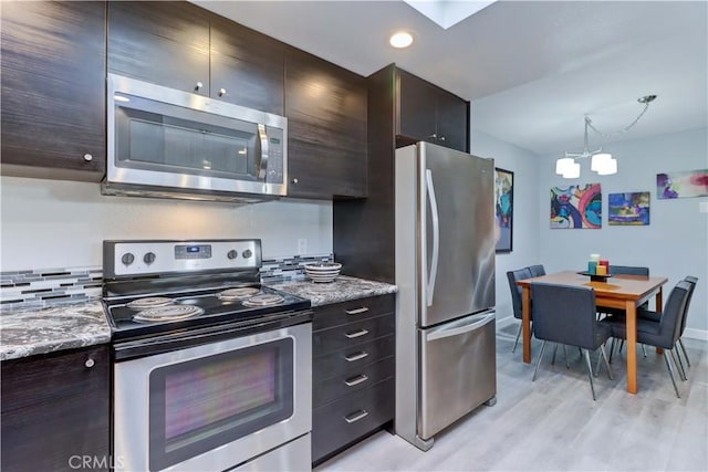 774 Via Los Altos Unit P, Laguna Woods, CA 92637 - kitchen with stainless steel appliances, a chandelier, light wood-type flooring, baseboards, and light stone countertops