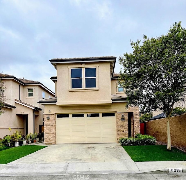 view of front of house featuring driveway, fence, a garage, stucco siding, and stone siding