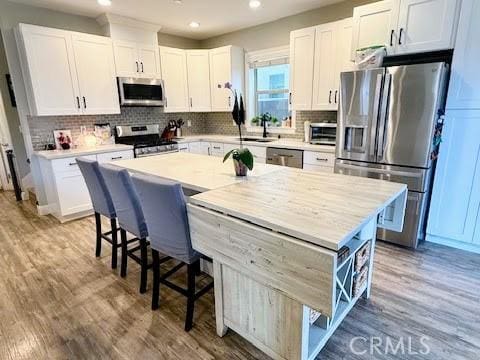 kitchen with white cabinetry, stainless steel appliances, recessed lighting, and a sink