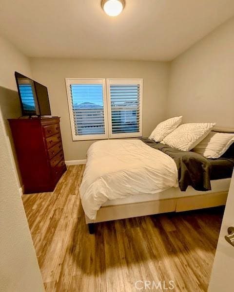 bedroom with baseboards and wood finished floors
