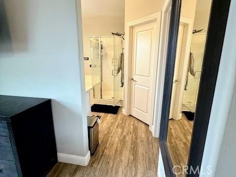 hallway featuring baseboards and wood finished floors