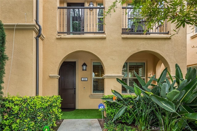 102 Rose Arch Unit 23, Irvine, CA 92620 - view of exterior entry with a balcony and stucco siding