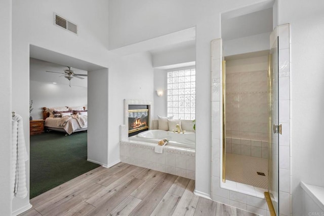 3048 Jason Rd, Fallbrook, CA 92028 - ensuite bathroom with wood finished floors, a garden tub, ceiling fan, a stall shower, and a multi sided fireplace