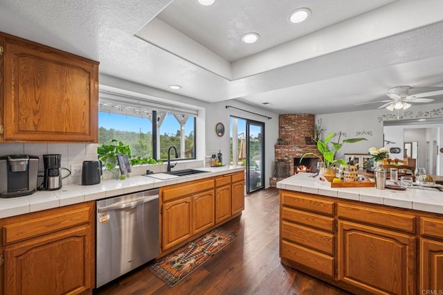 3048 Jason Rd, Fallbrook, CA 92028 - kitchen with stainless steel dishwasher, a sink, dark wood-style floors, tile counters, and brown cabinetry