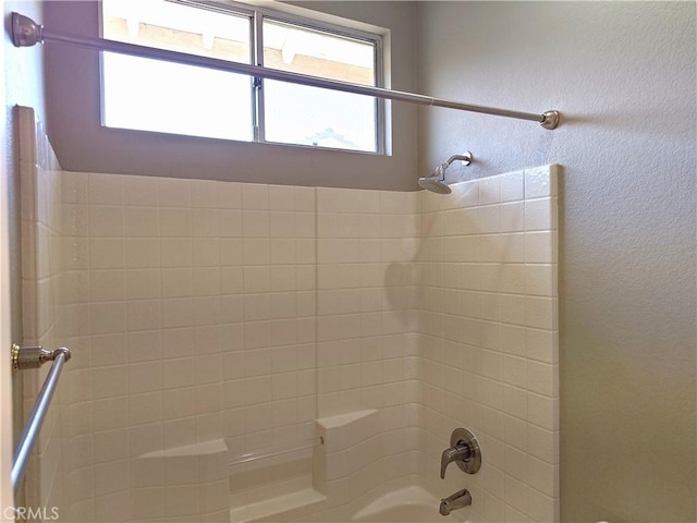 full bath featuring  shower combination and a textured wall