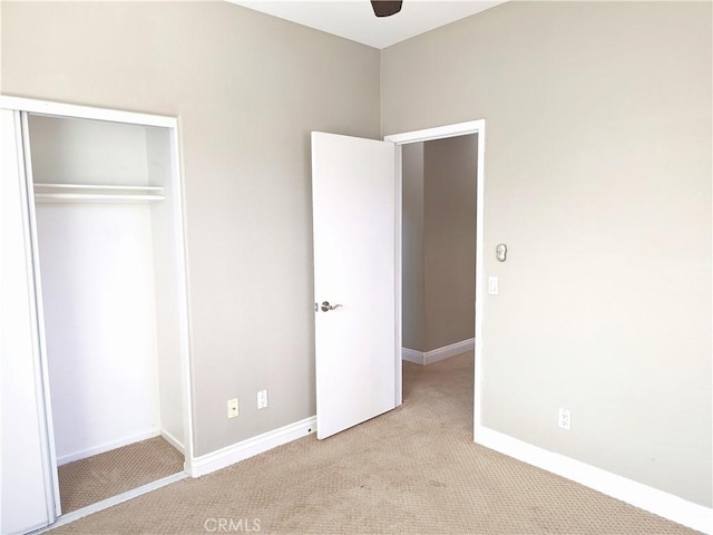 unfurnished bedroom featuring baseboards, carpet flooring, and a closet