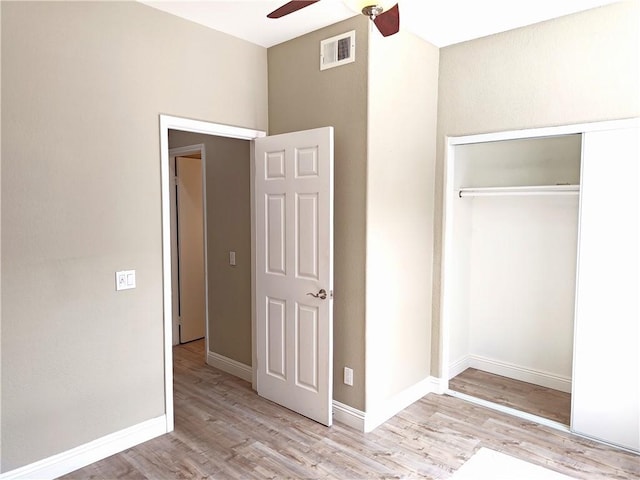 unfurnished bedroom with a ceiling fan, a closet, baseboards, visible vents, and wood finished floors