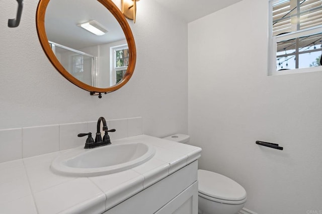 2705 Plumeria Dr, Carlsbad, CA 92009 - full bathroom featuring vanity, toilet, a stall shower, and a healthy amount of sunlight