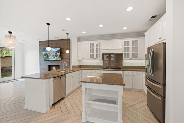 2705 Plumeria Dr, Carlsbad, CA 92009 - kitchen with a peninsula, a sink, open shelves, visible vents, and appliances with stainless steel finishes