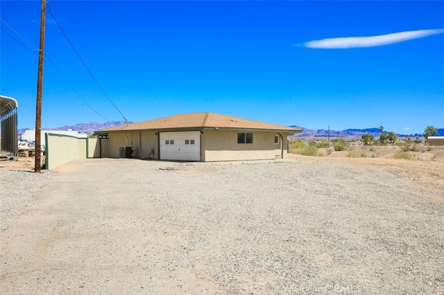 150020 Bluewater Rd, Big River, CA 92242 - view of front of property featuring central air condition unit, an attached garage, a mountain view, and driveway