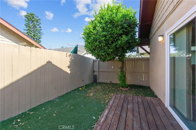 wooden deck featuring a lawn and a fenced backyard