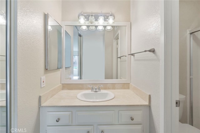 bathroom featuring vanity and a textured wall