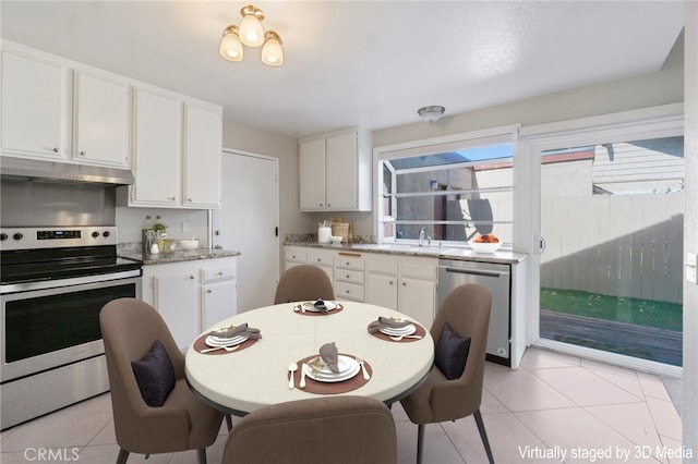 kitchen with white cabinetry, stainless steel appliances, light tile patterned floors, and under cabinet range hood